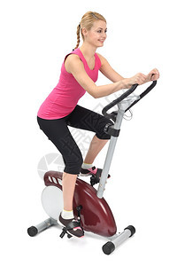 年轻女子在室内骑自行车打白底排练健身房竞技白色的图片