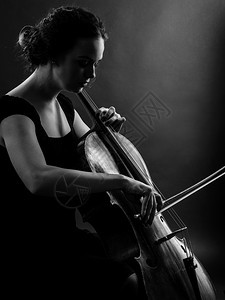 大提琴手黑色的细绳一位美丽女音乐家播放大提琴BacklitBlacklit黑白图像A的照片图片