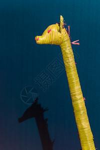 塑料长颈鹿手工制作蓝背景上的黄WickerGiraffe装饰玩具图片