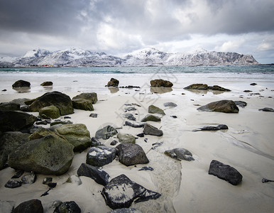岛屿冬季挪威海湾的落岩岸与挪威洛福滕群岛豪克兰海滩下雪斯堪的纳维亚云图片