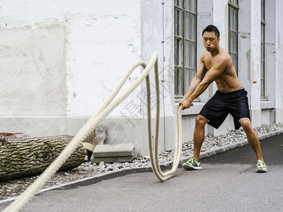 男英俊的照片中一位亚洲肌肉男子在健身训练室外用绳子对户训练时使用绳子水平的图片