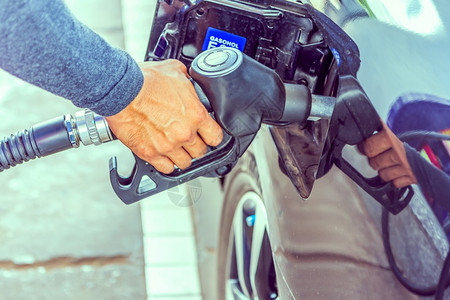 填旅行燃料喷嘴在加油站汽车中添燃料服务图片