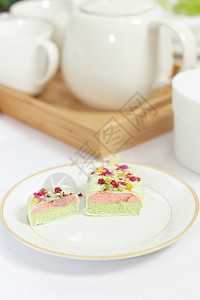 切片冰蛋糕在盘子上茶壶和杯放在桌上的木托盘粉色白棒冰图片