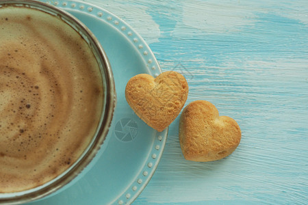 爱两个心形的曲奇饼干放在咖啡杯附近的一个碟子上休息种图片