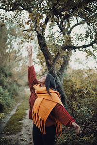 橙秋天年轻女人想从树上抓一只梨子黑色的图片