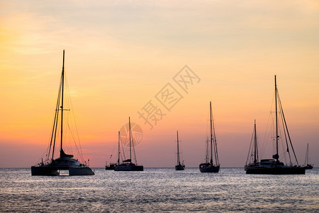 轮廓太阳日落时海上帆船停靠的轮椅假期图片