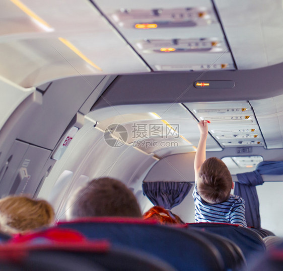 婴儿乘客童伸手可及机舱内的开关家庭旅行概念儿童伸手可及机舱内的开关人们图片