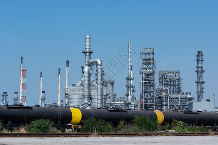 以天空为背景的管道石油炼厂的烟囱和植物一种制造业图片