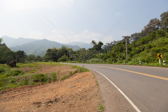 沥青山上的道路横穿坡沿的树丛清除运输图片