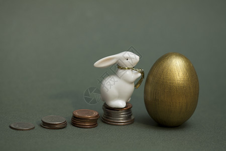 繁荣一种堆叠的硬币金蛋和白兔储蓄图片