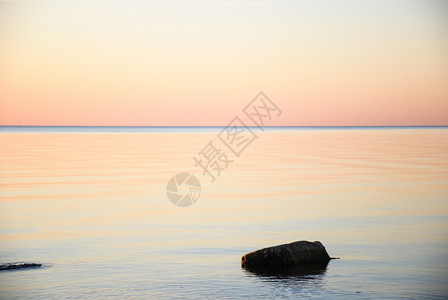 晚的日落在深夜太阳下以柔软的彩色和平静水海滩图片
