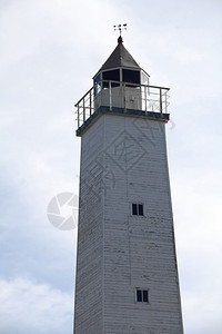 海洋支撑旧木制灯塔在云天背景上有一个观察台站的老木制灯塔户外图片