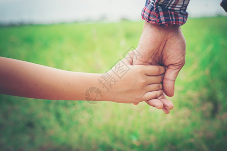 手指父亲近地握着女儿的手如此甜蜜温柔的家庭时光接触年轻的图片