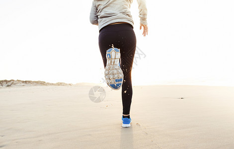 日落美丽健康的女人在沙滩上奔跑背部阳光图片