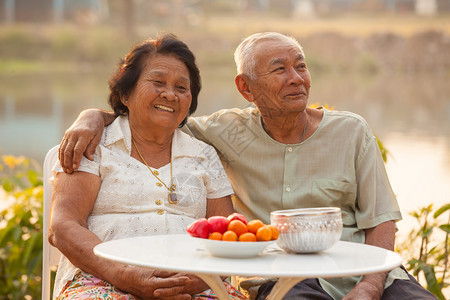 退休浪漫的日落时坐在户外的亚洲幸福老年情侣图片