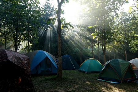 背包旅行山荒野在有阳光背景的营地帐篷露图片
