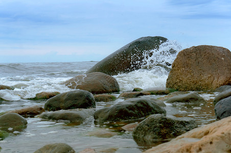 海边的巨石浪打在头上波浪打碎海边的巨石岸线溅蓝色的图片