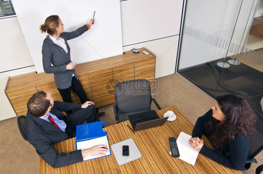 电脑笔记常设3名年轻的商业伙伴在一次会议上相其中1人在白屏幕前提出理论图片
