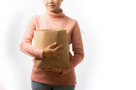 成人年轻女在白色背景上持有空纸袋用于商品的空白纸袋购物者食图片