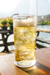 液体玻璃透明杯啤酒和木制桌上的冰图片