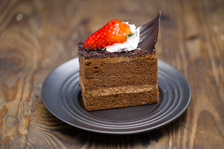 蒸着棕色的苦恼烧焦木材碟中巧克力蛋糕的切片图片