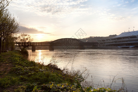 人们联合的美国宾夕法尼亚州匹兹堡市日落时横跨阿列根尼河的桥水图片