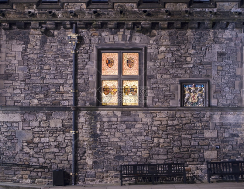 下一个照明细节夜晚爱丁堡城大会堂外墙印有苏格兰前国王徽章的彩色玻璃窗正在黑暗中闪耀着皇室象征旁边的光芒在黑暗中图片