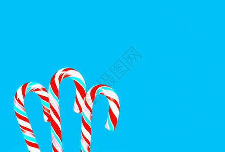 蓝色背景的红甘蔗和绿宝石棒糖贺卡假日背景有空间复制与棒糖的节日蓝背景假期一种白色的图片