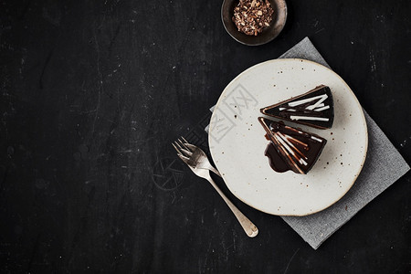 黑暗的餐桌上有一块美味的自制巧克力蛋糕好吃的自制巧克力蛋糕好吃的自制巧克力蛋糕卡路里送达图片