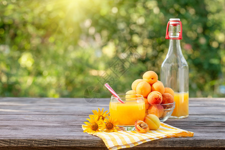 橙门户14木桌上杏黄花汁方格色餐巾纸绿自然背景木桌上杏黄花汁木制的图片