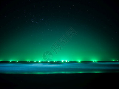 海滩夜晚上地平线的绿光渔船灯天空上星和波浪软移动泰国绿色图片