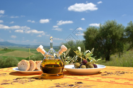 夏天食物蔬菜木制桌上的橄榄油和意大利图斯卡风景图片