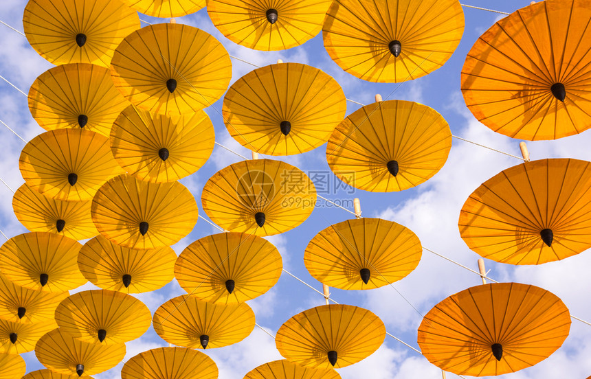 装饰丰富多彩种类在户外挂着黄色雨伞的许多装饰品图片