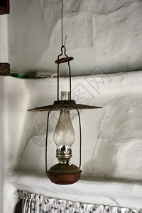古老的装饰绞刑在农村炉灶旁边的天花板上挂着旧煤油灯图片
