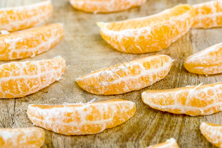 清除木板上大量纯净的曼达林切片在冬季马达林木板上关闭柑橘仁圆圈饮食图片