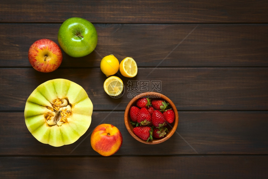 以天然光照在深木头上拍摄的各种新鲜水果蜂蜜甜瓜内橘苹果草莓梅子柠檬新鲜的营养图片