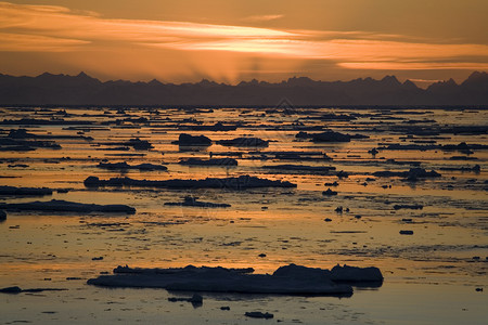 冰山海和北极高地斯瓦尔巴群岛匹茨贝根西海岸斯匹兹堡山脉的深夜日光漂浮超过图片