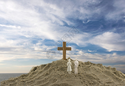 宗教的看着沙山上木制圣的玩具夫妇信仰海滩图片