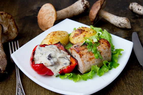 健康食物蔬菜猪肉牛排加烤土豆和白盘蘑菇酱图片