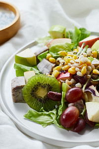 美味水果沙拉和白桌上不同水果健康食品概念在白色桌子上开胃菜吃晚餐图片