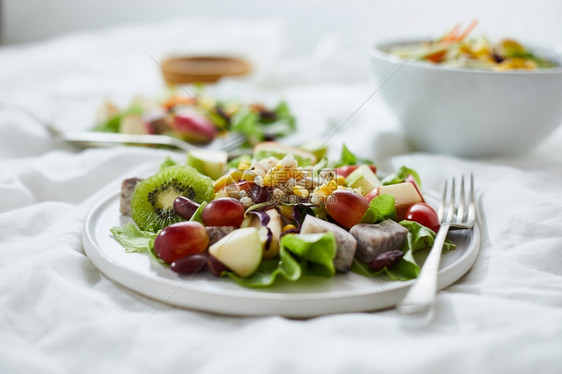 食谱绿色有机的美味水果沙拉和白桌上不同水果健康食品概念在白色桌子上图片