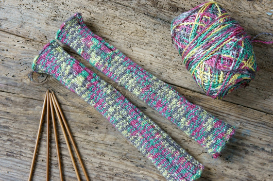 妇女手工编织羊毛套制作圣诞节礼物为寒冬的特别礼物彩色的羊毛球木制背景两针创辉木制的聪明图片