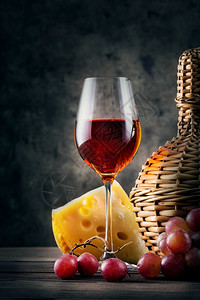 老的深色背景中带葡萄和柳条瓶的红酒杯带葡萄和柳条瓶的红酒杯馆黑色的图片