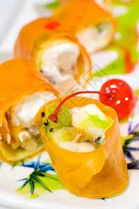 梨糖寿司卷和水果包装在米纸上宏观橙东方的图片