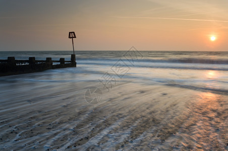 日出在天鹅海边多塞特英格兰国反射波浪黎明图片