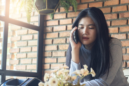 打电话在咖啡馆来智能手机的亚洲女孩咖啡店漂亮的图片