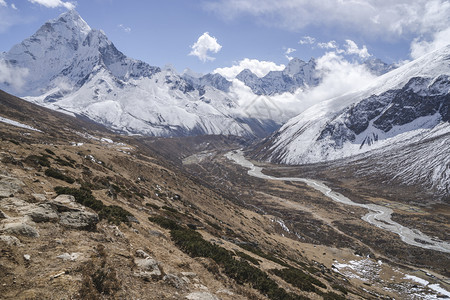 蓝天白云下的雪山峡谷风光图片