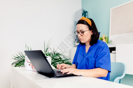 沟通浏览联系诊所使用膝上型电脑的女医生图片