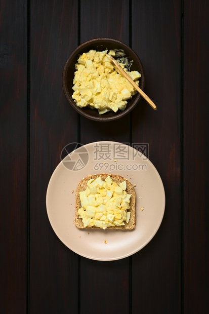 饮食早餐调味品鸡蛋沙拉三明治新鲜自制鸡蛋沙拉配有黄酱和芥末加全谷物面包的胡椒和芥子酱用自然光照在深木头上图片