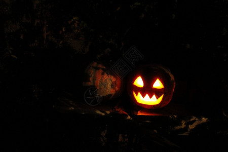 灯笼阴影万圣节恐怖鬼脸上闪耀的亮面罩在黑暗中的万圣节庆典图片